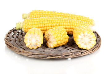 Fresh corn on wicker mat isolated on white