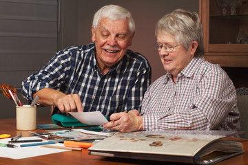 Happy senior couple making a scrapbook