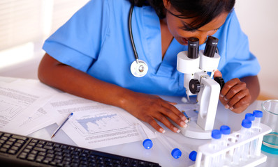 Pretty nurse working at laboratory in blue uniform
