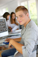 Young man sitting in office in front of desktop computer