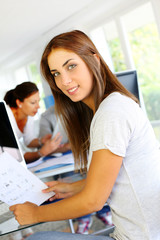 Beautiful office worker sitting in front of desktop