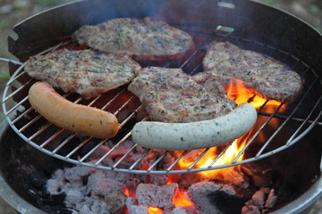 Grillfleisch und verschiedene Bratwürste auf dem Grill
