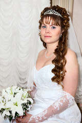 Beautiful bride portrait in white dress and with lilies flowers