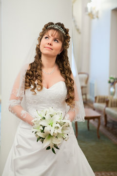 Attractive bride in white dress looking far away, copyspace