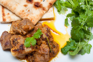 Lamb curry cirrander and Naan close up on a white plate
