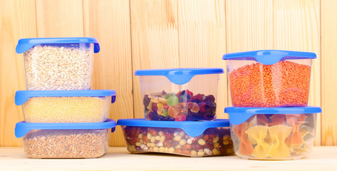 Filled plastic containers on wooden background