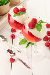 fruit jelly with raspberries in glasses on wooden table