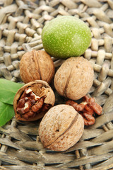walnuts with green leaves, on  wicker background