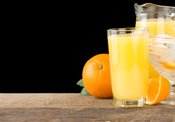 juice and oranges isolated on black