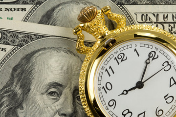 gold watch on dollar banknotes