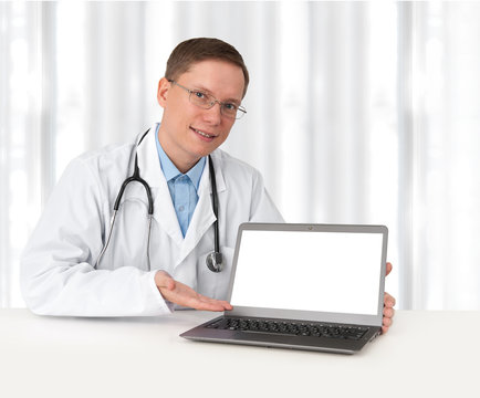 young doctor in lab coat with laptop