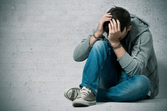 Jugendlicher mit  Handschellen