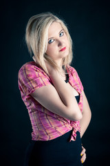 Portrait of blonde teenager girl on black background.