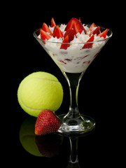 Strawberry with cream and a tennis ball.
