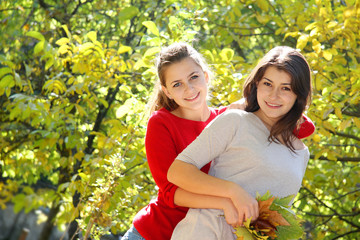 two young happy women on natural autumn background