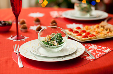 Decorated Christmas dining table with delicious salad (spinach,