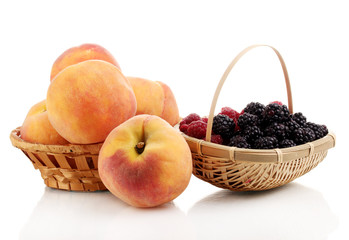 Ripe raspberries, brambles and peaches isolated on white