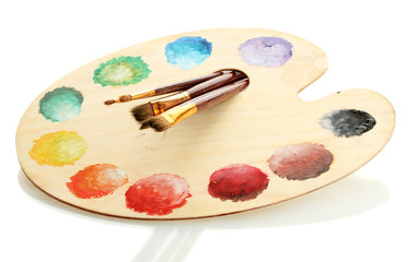 wooden art palette with paint and brushes isolated on white
