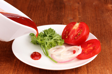 Ripe slices tomato on plate on wooden table
