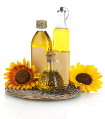 oil in bottles, sunflowers and seeds isolated on white