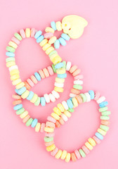 Color candies on rope on pink background