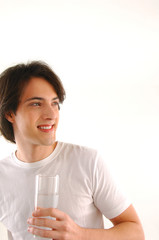Young man holding a glass of milk on white.