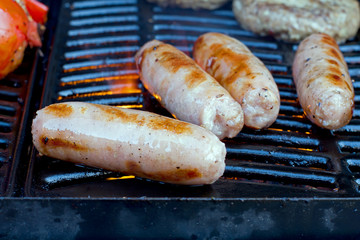 sausages slowly cooking on the barbecue
