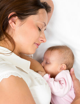 close-up portrait of mother breast feeding her baby infant