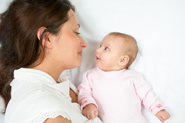 joyful mother playing with her baby infant