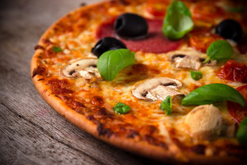 Tasty Italian pizza on wooden background