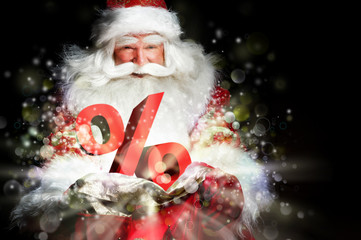 Santa Claus holding his bag and smiling. Lights and sparks are f