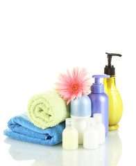 Obraz na płótnie Canvas cosmetics bottles with towels and flower isolated on white
