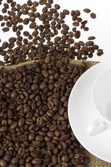 kaffebohnen auf einem leinensack mit kaffeetasse hochformat