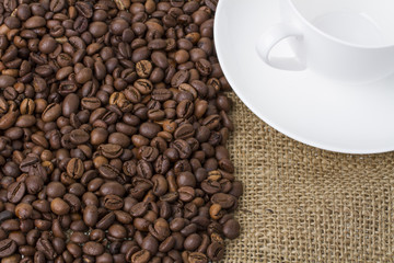 kaffebohnen auf einem leinensack mit kaffeetasse