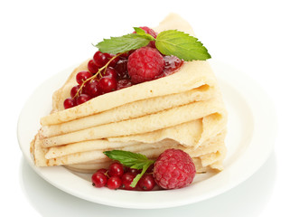 Delicious pancakes with berries and jam on plate on wooden