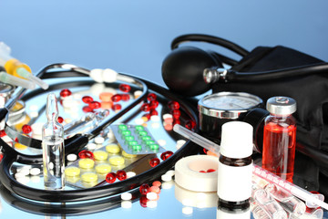 medicines and a stethoscope on a blue background close-up