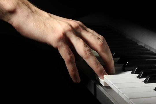 hand of man playing piano