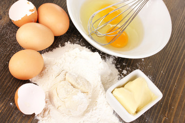 Eggs, flour and butter close-up on wooden table
