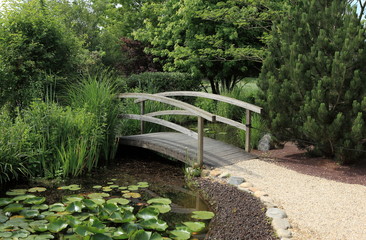 Fototapeta na wymiar mały drewniany most nad wody ogród