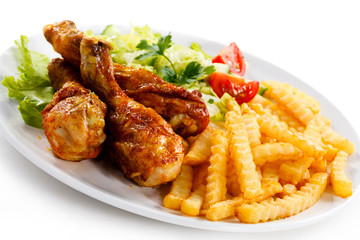 Grilled chicken legs with chips and vegetables