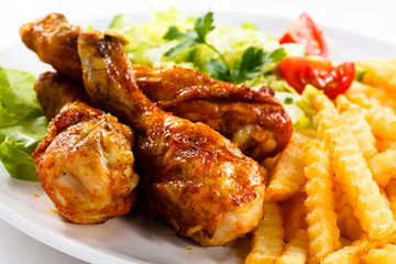 Grilled chicken legs with chips and vegetables