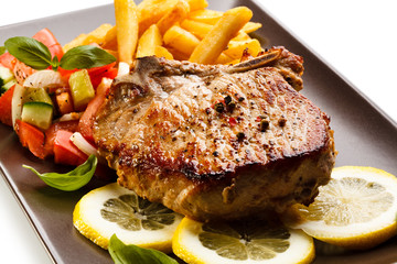 Grilled steaks, French fries and vegetables