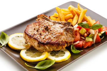 Grilled steaks, French fries and vegetables