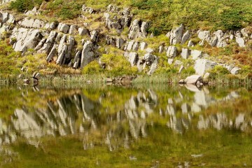 rocks reflection on a mountain lake surface.