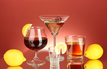 a variety of alcoholic drinks on red background