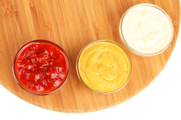 various sauces on chopping board isolated on white
