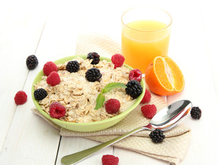tasty oatmeal with berries and glass of juice,