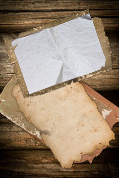 Ragged old paper sheets on a wooden background