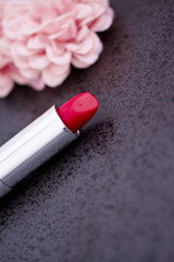 red lipstick and pink flower petals on black