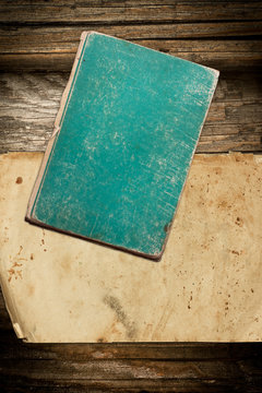 Weathered book and paper roll on wood